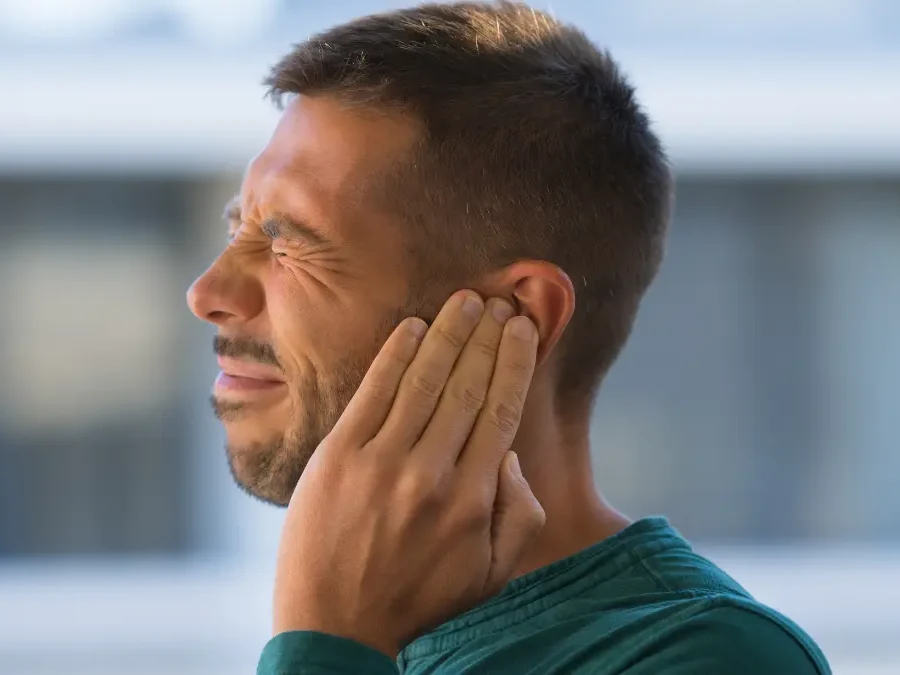 Una persona con la mano sull'orecchio